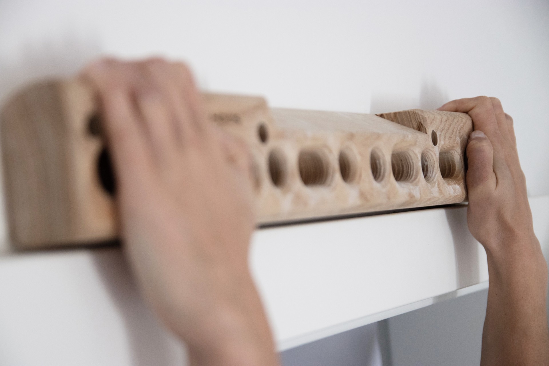 Woman climber training strength on fingerboard at home Woman climber training strength on fingerboard at home